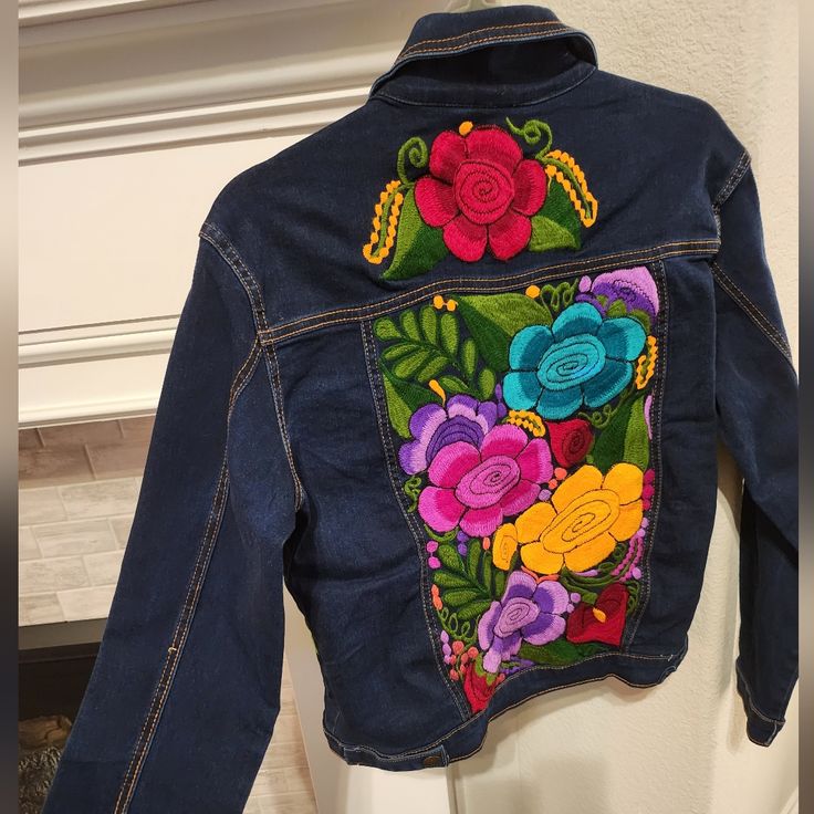 a denim jacket with flowers painted on it