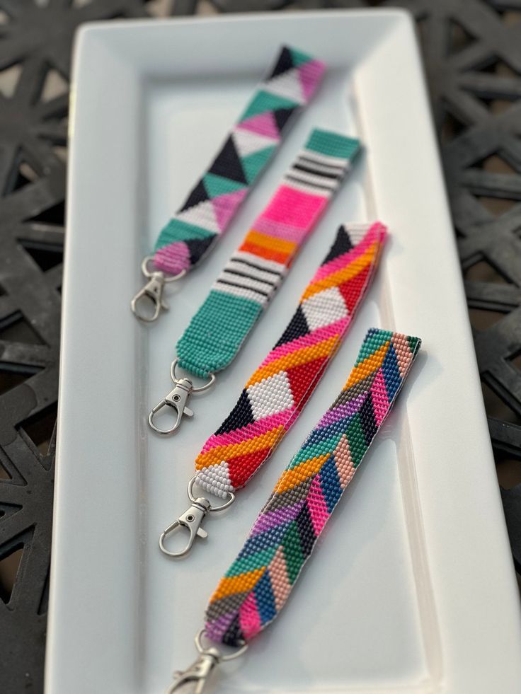 three colorful key chains on a white plate