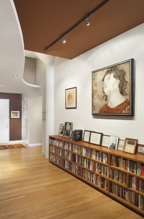 an empty room with bookshelves and pictures on the wall in front of it