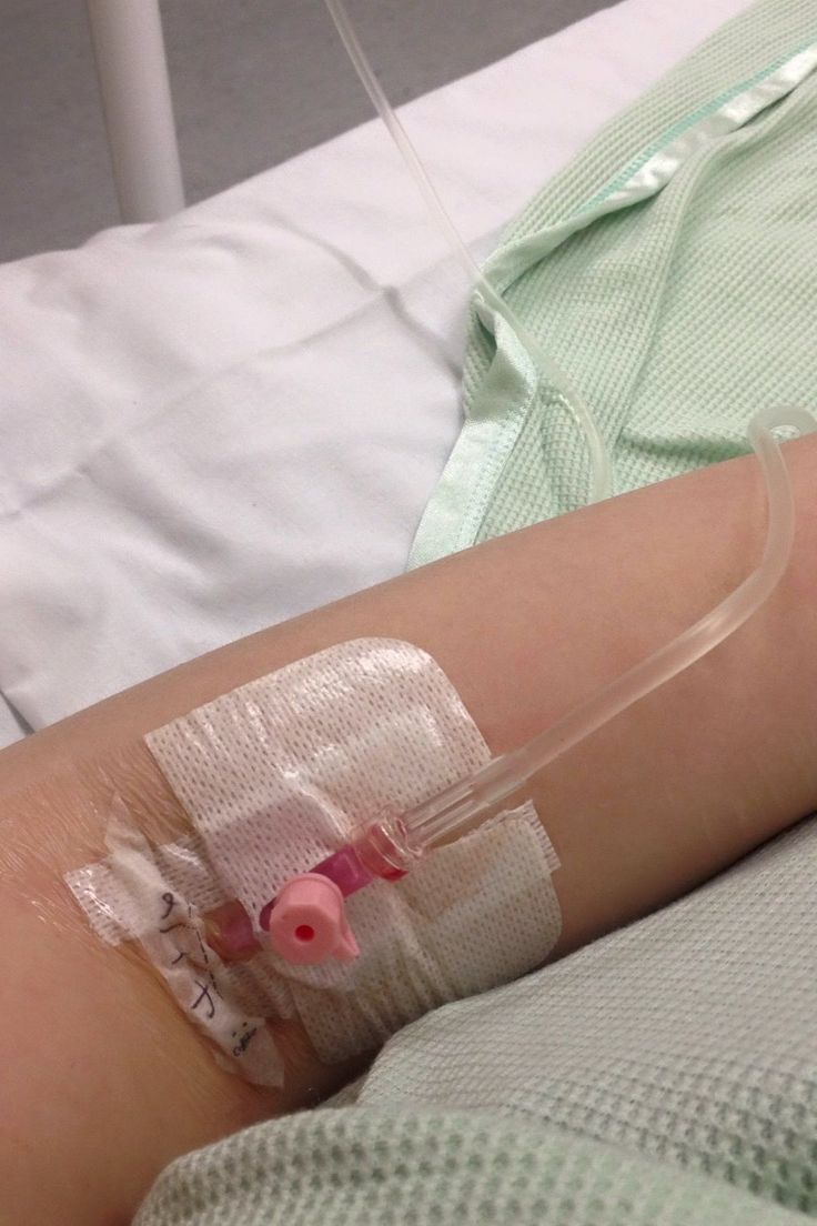 a person in a hospital bed with an iv tube attached to their arm