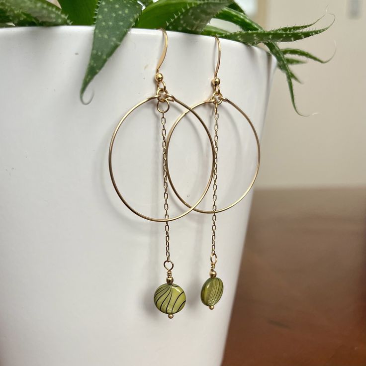 Delicate hoop earrings contrasted with beads dangling from chair on ear wire. Wear them casually to your favorite coffee shop or dress them up for a night out! They come in pink and green. Trendy Wire Wrapped Drop Earrings, Trendy Wire Wrapped Dangle Earrings, Trendy Dangle Wrap Earrings With Ear Wire, Trendy Dangle Wrap Earrings, Trendy Adjustable Dangle Hoop Earrings, Trendy Dangle Hoop Earrings In Brass, Everyday Wire Wrapped Beaded Dangle Earrings, Green Hoop Earrings For Party With Ear Wire, Trendy Adjustable Dangle Wrap Earrings