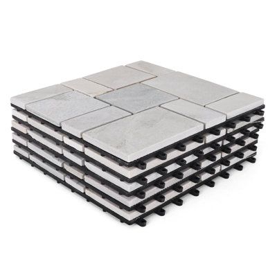 a stack of white and black tiles sitting on top of each other in front of a white background