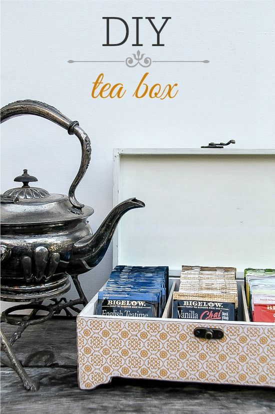 a tea box with some books in it next to a kettle and cup on a table