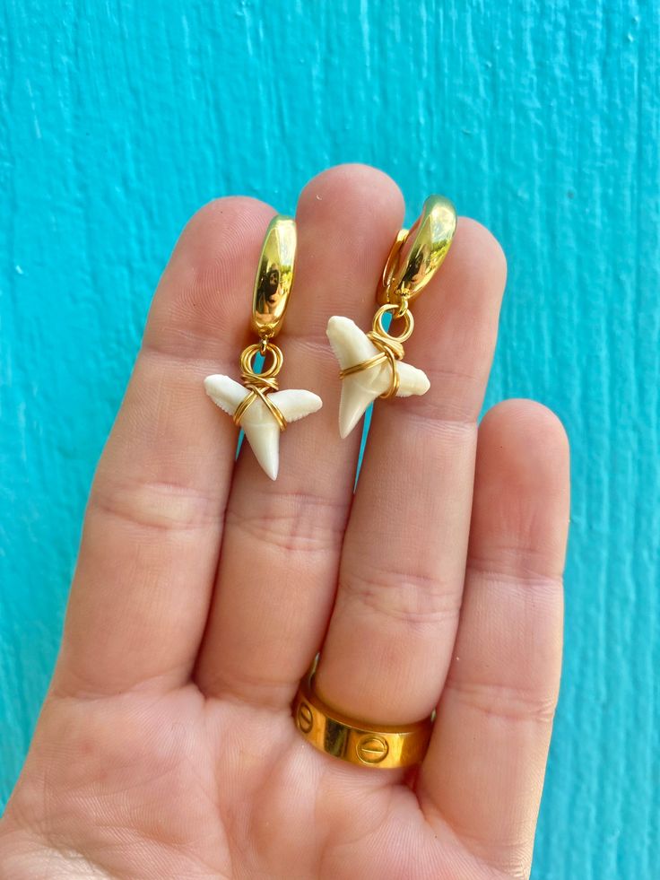 These shark tooth earrings are the cutest, they have a white gold like huggie hoop. The hoops are 18K gold plated and lead and nickel free. They then have two white lemon sharks teeth on them and they are wire wrapped with white gold non tarnishing wire! 🦈 Nickel Free White Huggie Jewelry, Nickel-free White Huggie Jewelry, White Nickel-free Huggie Jewelry, Nickel-free White Huggie Earrings For Gifts, Small Hoop White Huggie Earrings In 14k Gold, White 14k Gold Filled Huggie Earrings, White Wire Wrapped Hoop Earrings Gift, White Wire Wrapped Hoop Earrings As A Gift, White Nickel-free Huggie Hoop Earrings