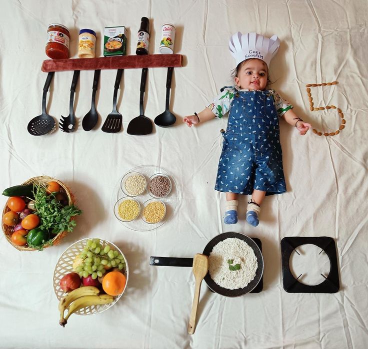 an assortment of cooking utensils on a bed with a doll in the middle