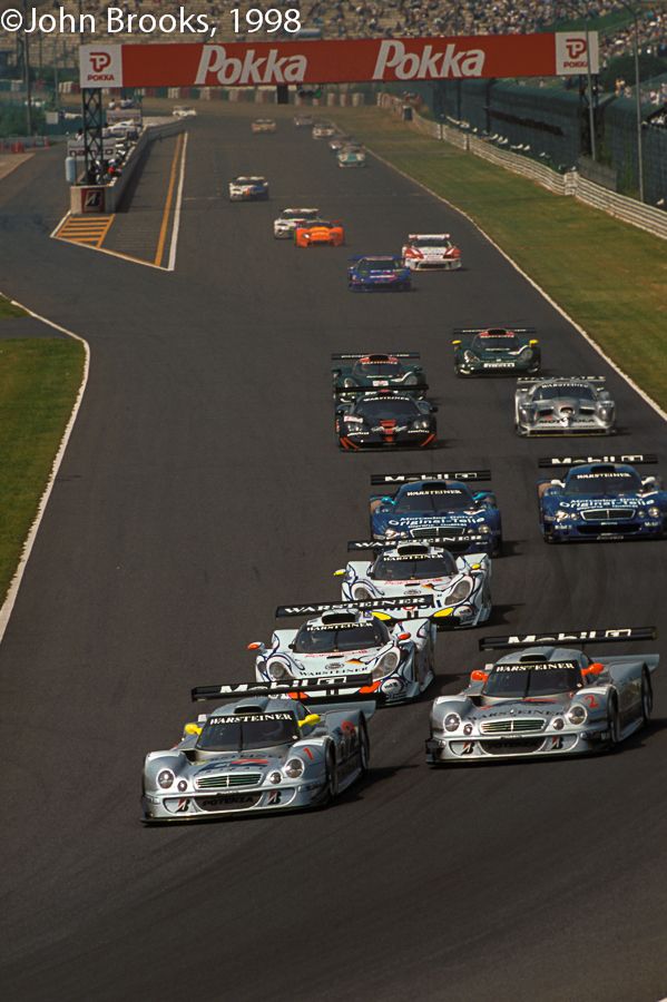 a group of cars driving down a race track