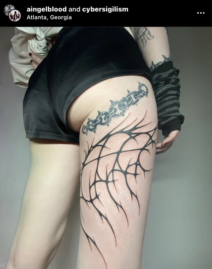 a woman's legs with tattoos on them and her leg in the shape of a spider web