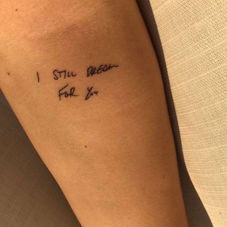 a person with a tattoo on their arm that reads, i still believe for ex