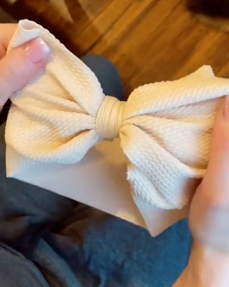 a close up of a person wearing a white bow tie on their fingernails