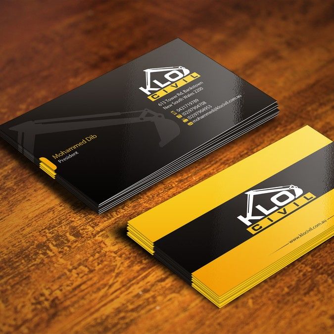 two black and yellow business cards sitting on top of a wooden table