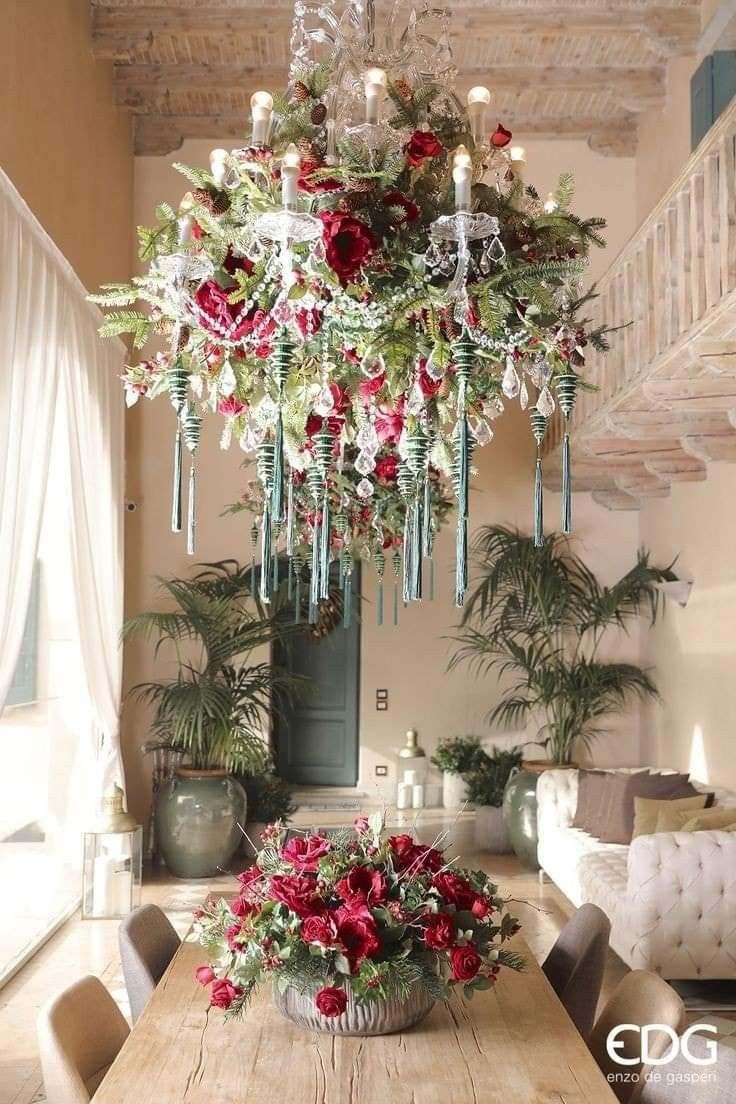 a chandelier hanging from the ceiling in a dining room with flowers on it