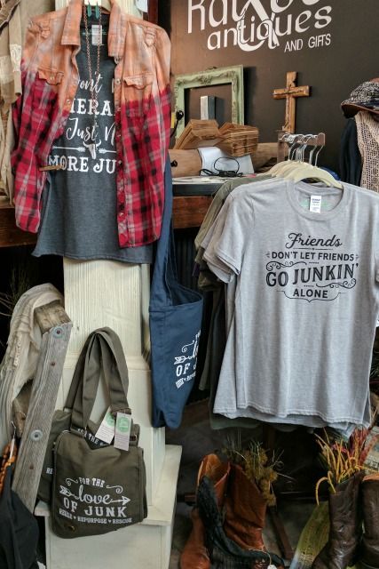 an assortment of t - shirts and other items on display