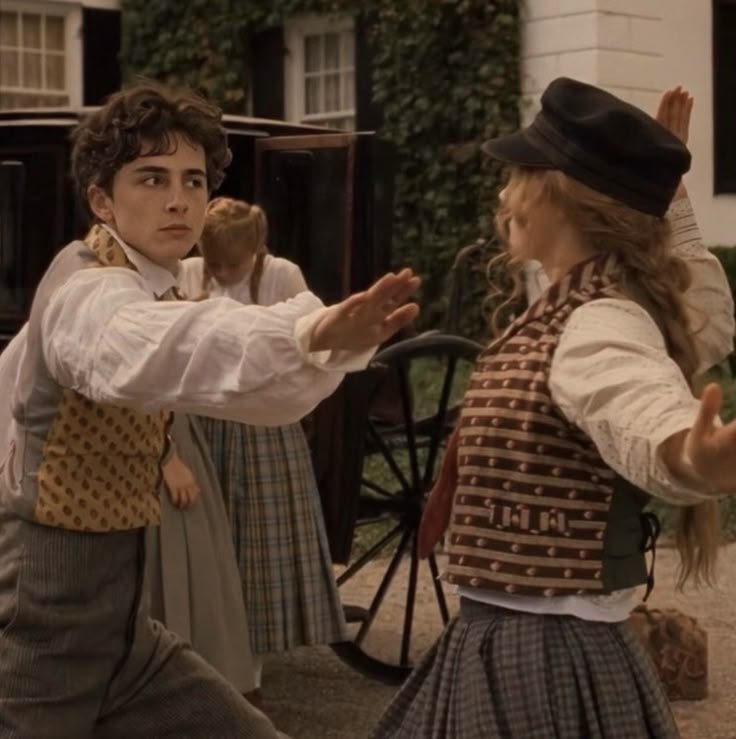 two children dressed in period clothing are dancing