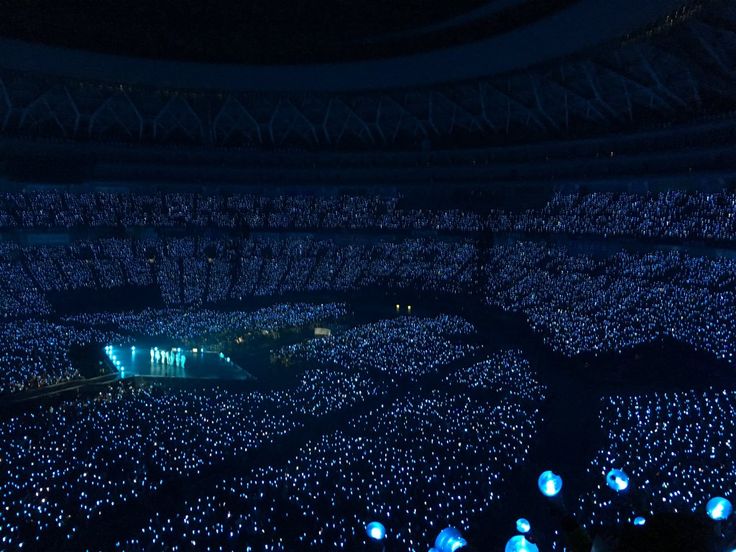 an aerial view of a concert venue at night with blue lights on the floor and in the ceiling