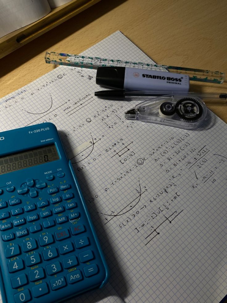 a calculator, pen and ruler sitting on top of a paper