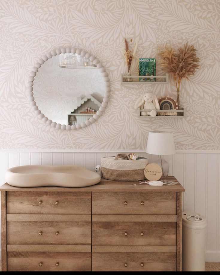 a dresser and mirror in a room with wallpapered walls, drawers and shelves