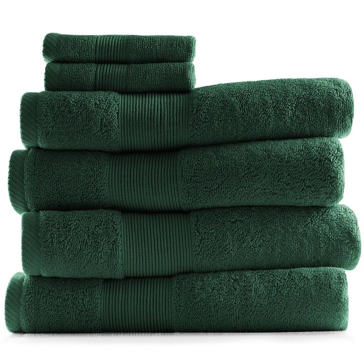 six dark green towels stacked on top of each other in front of a white background