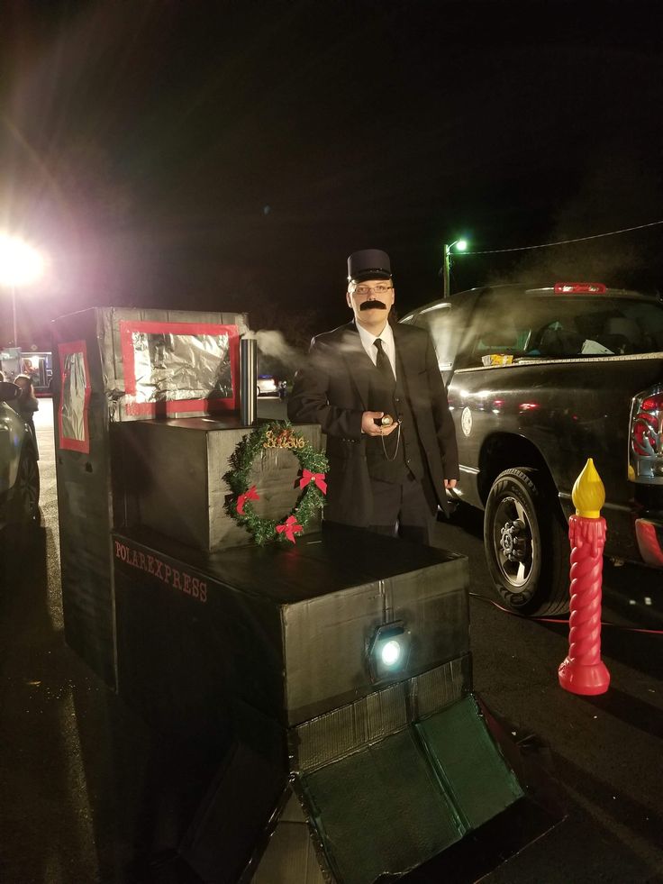 a man in a suit and tie standing next to a truck with christmas wreaths on it