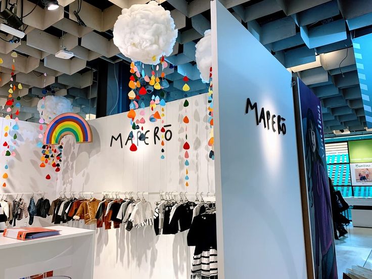 a store display with clothes and balloons hanging from the ceiling