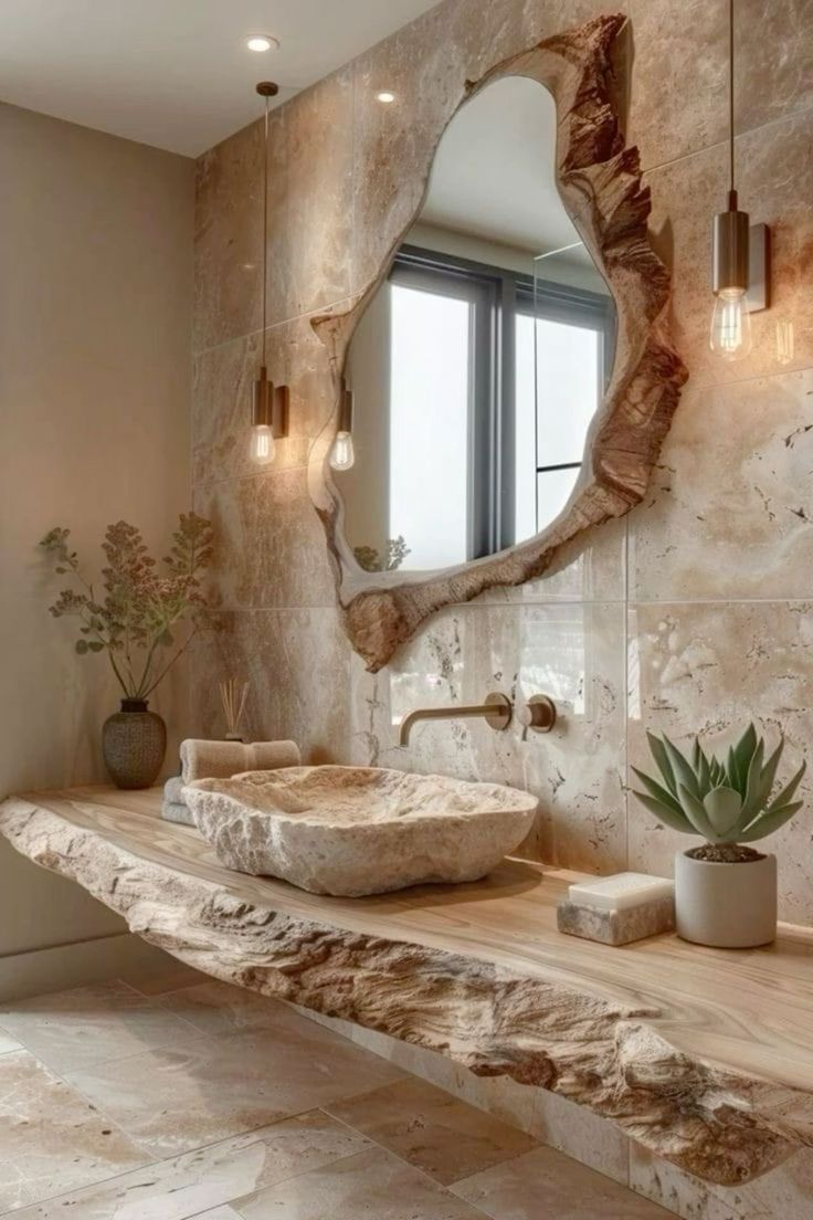 a bathroom with a stone sink and large mirror on the wall next to a potted succulent plant