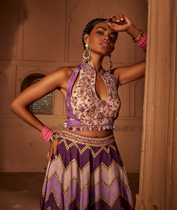 Make a style statement like a traditional diva in this alluring sharara set featuring geometrical print sharara coordinated with an intricately embroidered blouse with a stylised back design with heavy tassels and doris. Unstitched Blouse Sharara For Navratri, Bohemian Palazzo Set For Reception With Traditional Drape, Semi-stitched Sharara With Motifs, Bohemian Sharara With Cutdana For Reception, Purple Palazzo Set With Resham Embroidery, Bohemian Sharara For Reception, Bohemian Palazzo Set With Motifs For Festive Occasions, Multicolor Embroidered Palazzo Set, Bohemian Georgette Sharara For Designer Wear