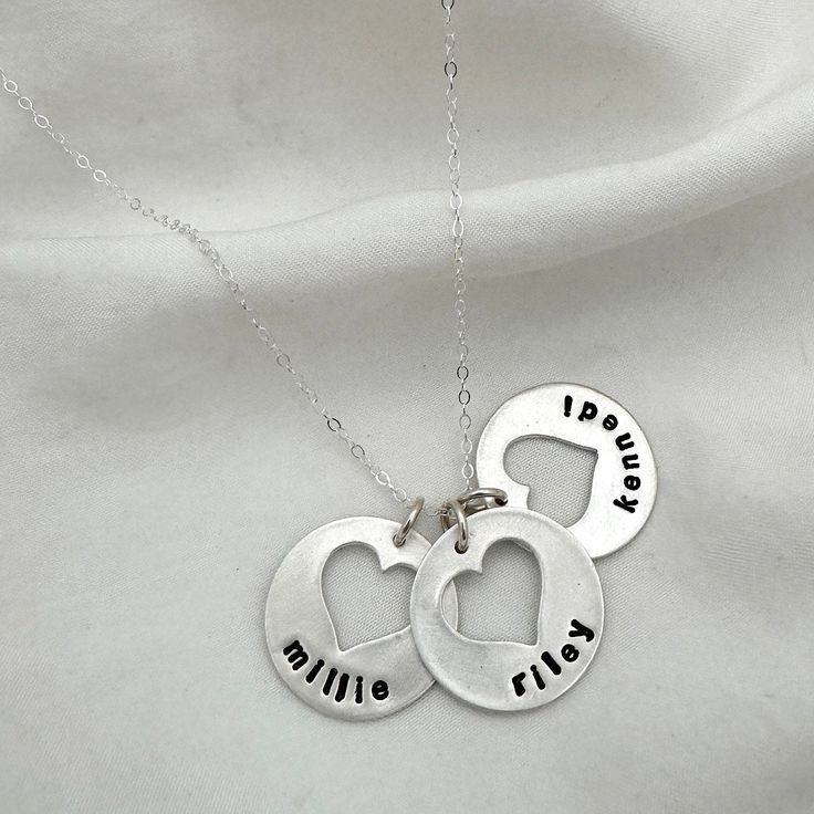 Keep your sweethearts close to you with one of our most beloved designs. Each heart cutout charm can be personalized with up to 8 characters. Add birthstones to make it a truly unique and special keepsake to be treasured forever. ~ Make it uniquely yours by visiting our Charm and Stone categories ~ Our personalized jewelry is made by hand. Please allow 1 to 2 weeks for your order to ship from our studio. Personalized Heart Charms For Birthday, Round Anniversary Jewelry With Heart Charm, Customizable Heart Pendant Necklace For Personalized Gift, Heart Charm For Birthday And Mother's Day, Personalized Charms For Valentine's Day Gift, Heart Pendant Charm Necklace For Birthday And Mother's Day, Charm Pendant Jewelry For Anniversary Gift, Customizable Heart Pendant Name Necklace For Personalized Gift, Heart Pendant Charm Necklace With Birthstone For Anniversary