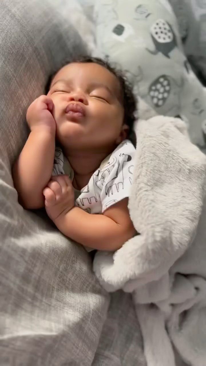 a baby is sleeping on a blanket with a stuffed animal