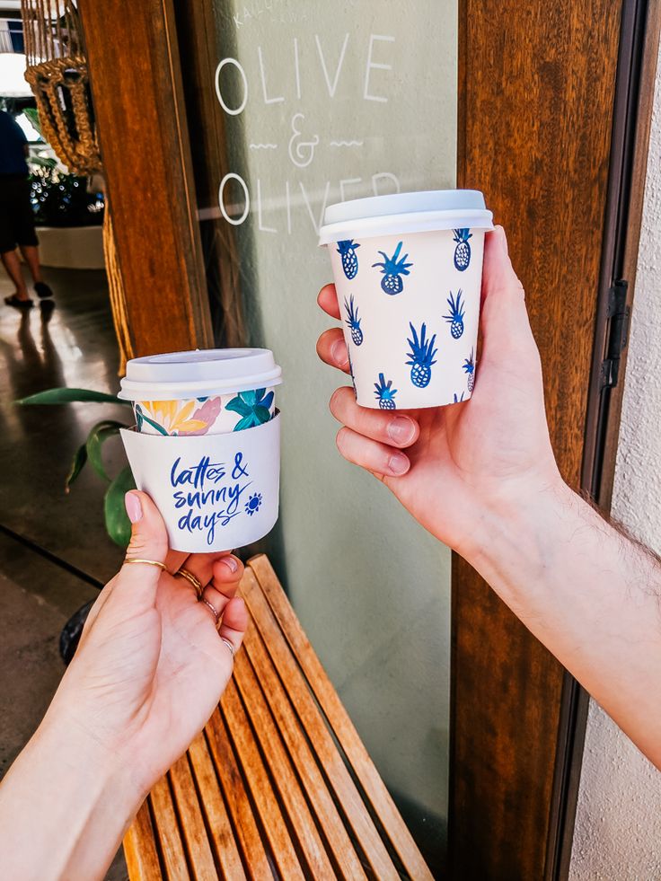 two people are holding up their coffee cups