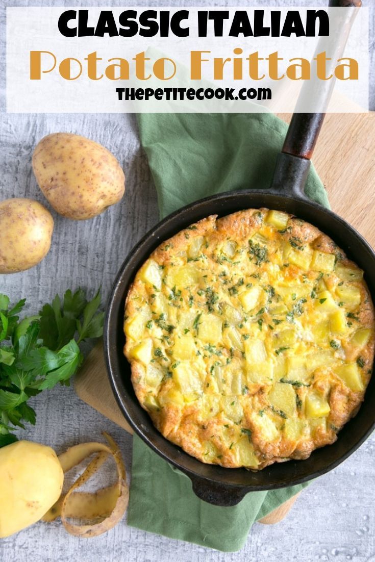 an omelet in a cast iron skillet next to potatoes and parsley