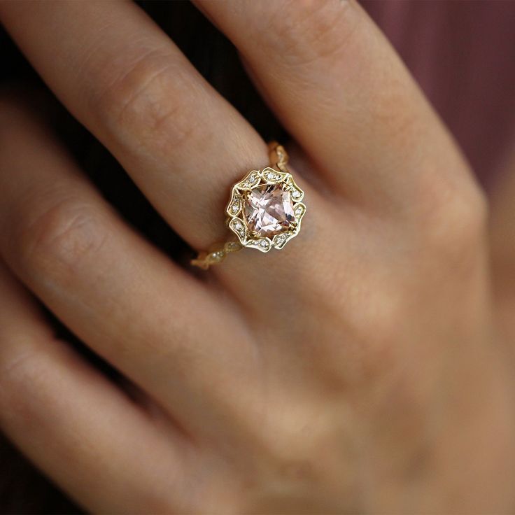 with an antique touch and a royal presence this ring is for a real princess. The center stone is a breathtaking morganite with a pinkish glow to it held by 8 magnificent claws. The stone is surrounded by 12 dazzling white diamonds set exquisitely in paisley like gold shapes. The band is waivy gold, dotted and encrusted with diamonds as well. This ring is just heart stopping from every angle. All features can be customized! please contact us if you wish to make changes, we love making custom designs. All of our jewelry is carefully handmade in our atelier *HC diamond are all conflict free diamonds To order by phone click here>> +972(0)722991000 Elegant Pink Gold Rings With Accent Stones, Radiant Cut Birthstone Ring With Center Stone For Weddings, Elegant Radiant Cut Birthstone Wedding Ring, Elegant Radiant Cut Birthstone Ring For Wedding, Elegant Pink Topaz Ring In 14k Gold, Luxury Wedding Birthstone Ring With Center Stone, Classic Morganite Wedding Ring With Brilliant Cut, Classic Pink Cluster Ring With Center Stone, Heirloom Morganite Diamond Ring For Formal Occasions