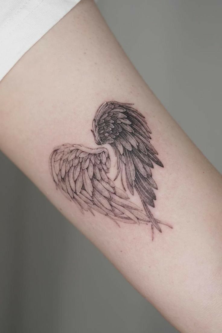 an angel wing tattoo on the arm