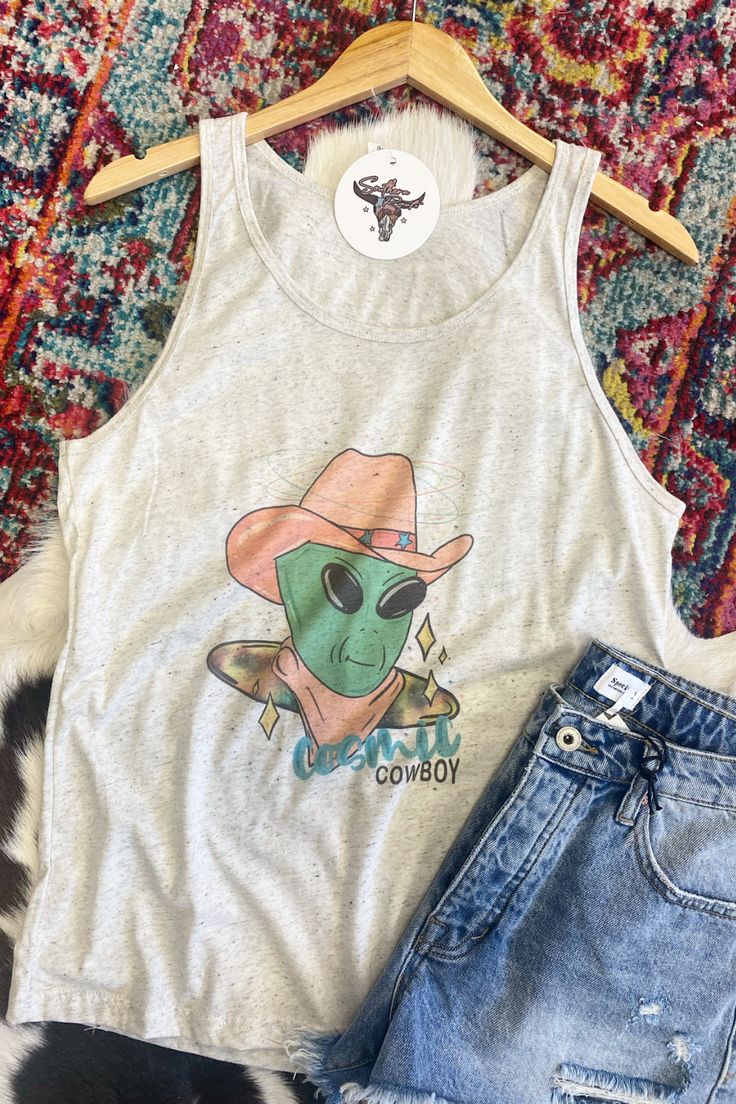 See you in space! How fun is this cosmic cowboy tank?? This tank is a flowy fit and would be such a fun addition to your summer wardrobe! We love how lightweight this tank is, it's perfect for those hot summer days! lightweight flowy 50% polyester, 25% cotton, 25% rayon Southern Roots Boutique112 W. Main St. Paragould, AR *Please allow 5-7 business days processing time for this item to be shipped/picked up. Casual Spring Vest With Graphic Print, Casual Graphic Print Vest For Spring, Summer Cotton Racerback Vest, Cute Tank Top For Summer, Fitted Fun Tank Top, Trendy Graphic Print Tank Top For Music Festival, Spring Graphic Print Racerback Tank Top, Fitted Summer Tank Top With Graphic Print, Summer Music Festival Tank Top With Graphic Print