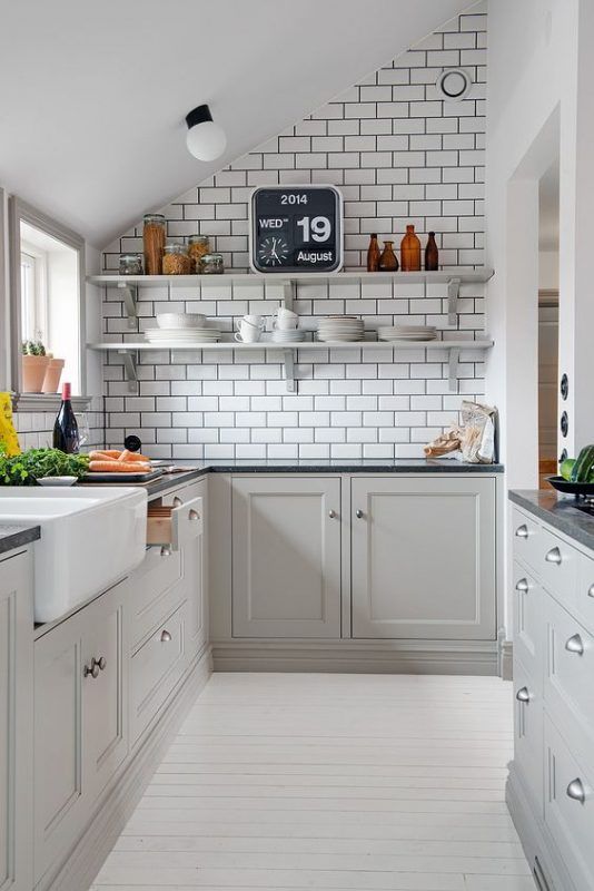 a kitchen with gray cabinets and white walls