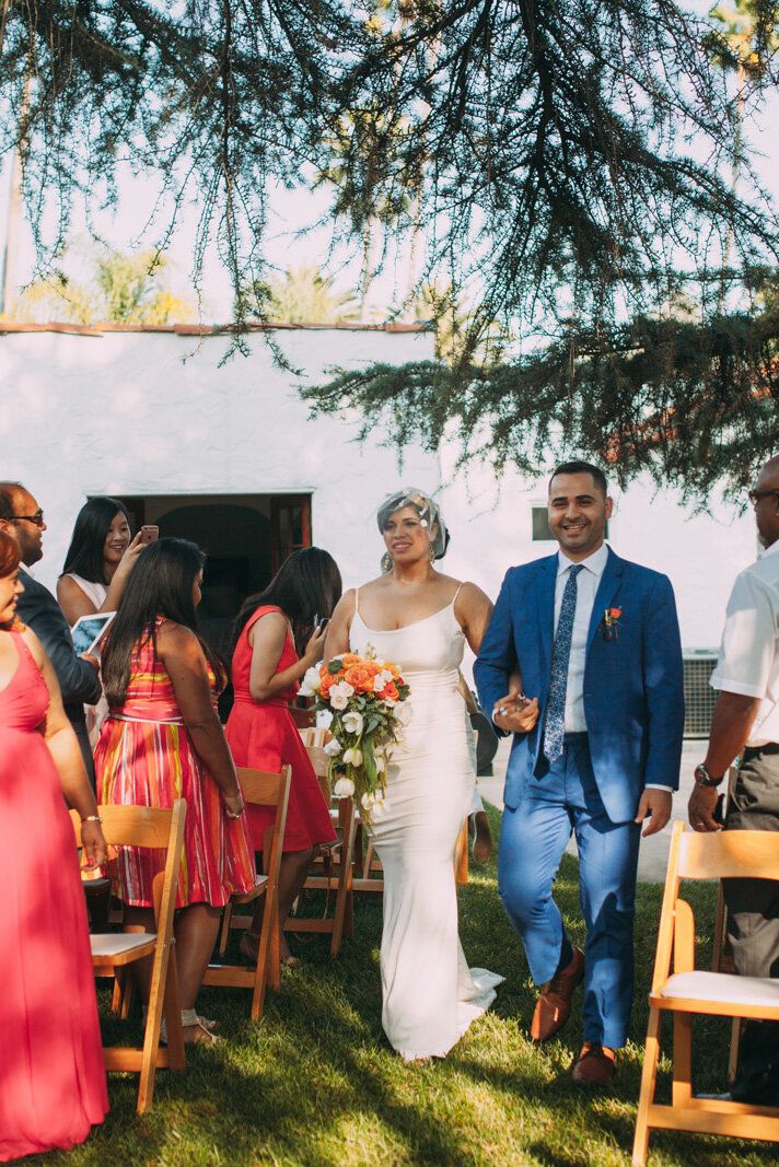 a bride and groom walking down the aisle after their wedding ceremony at an outdoor venue