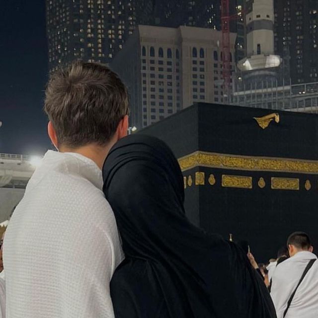 two people standing next to each other in front of the ka'bah at night