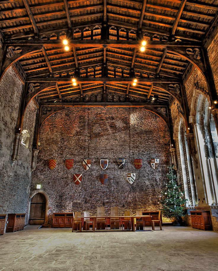 the inside of an old building with wooden beams and stone walls, decorated with christmas decorations