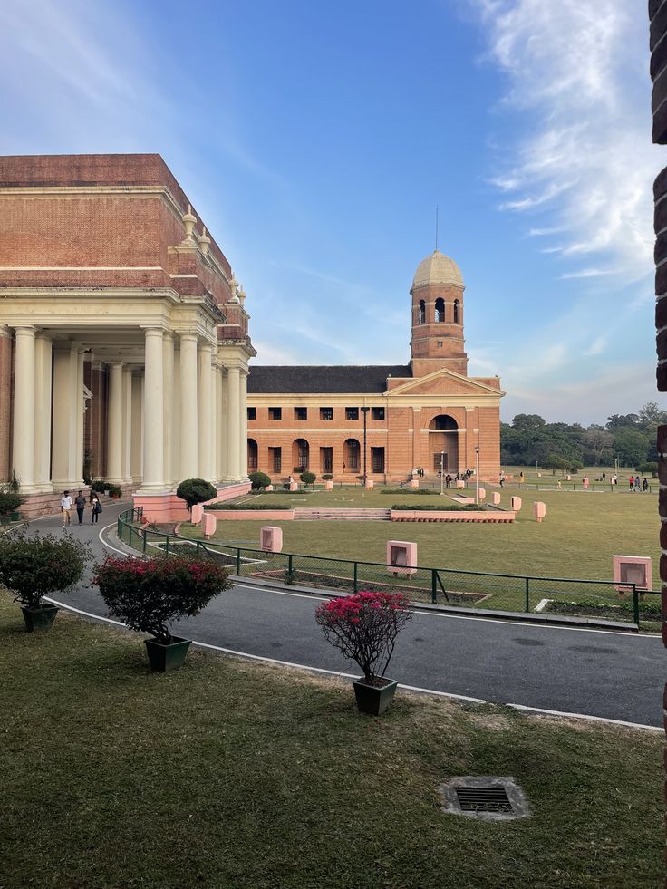 a large building with a clock tower in the middle of it's front yard