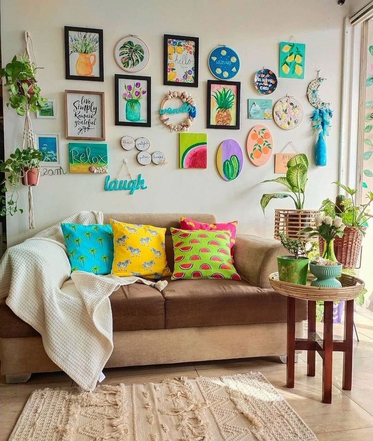 a living room filled with furniture and pictures on the wall above it is a brown couch covered in colorful pillows