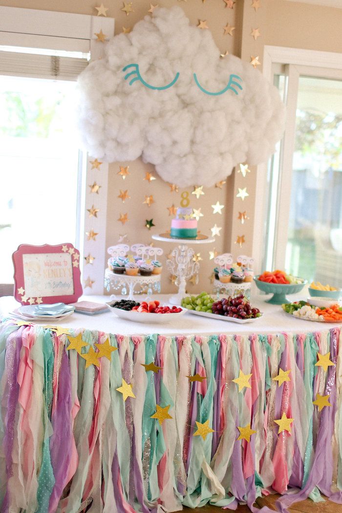 a table topped with cake and desserts under a cloud