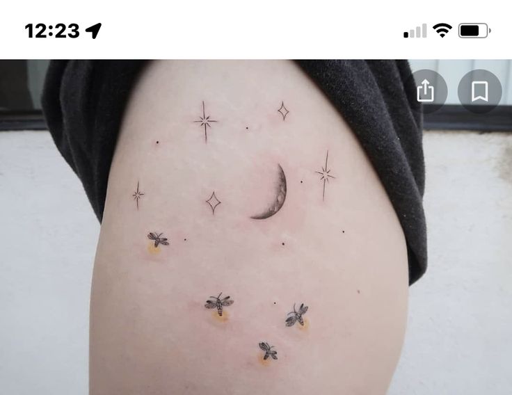 a woman's thigh with small stars and bees on it