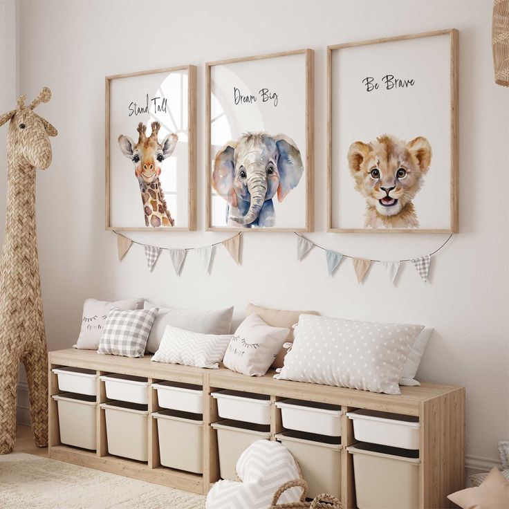 three pictures of animals hanging on the wall in a child's room with storage bins