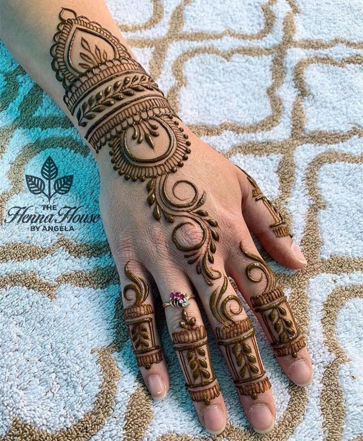 a woman's hand with henna tattoos on it