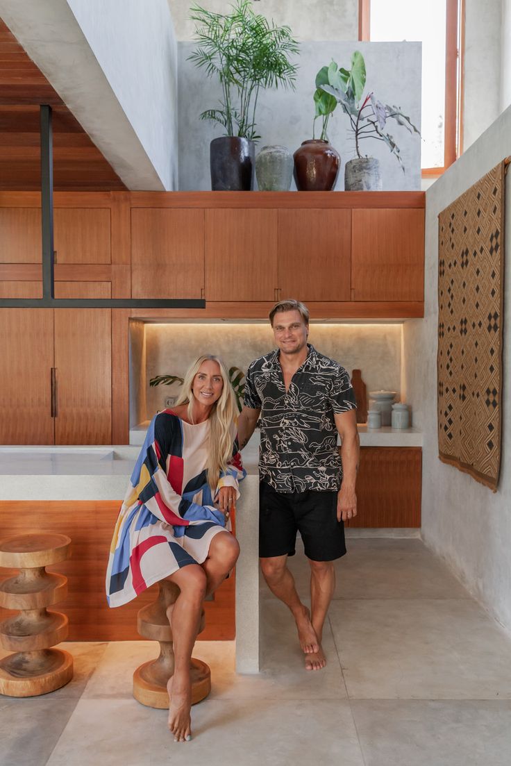 a man and woman standing next to each other in a kitchen