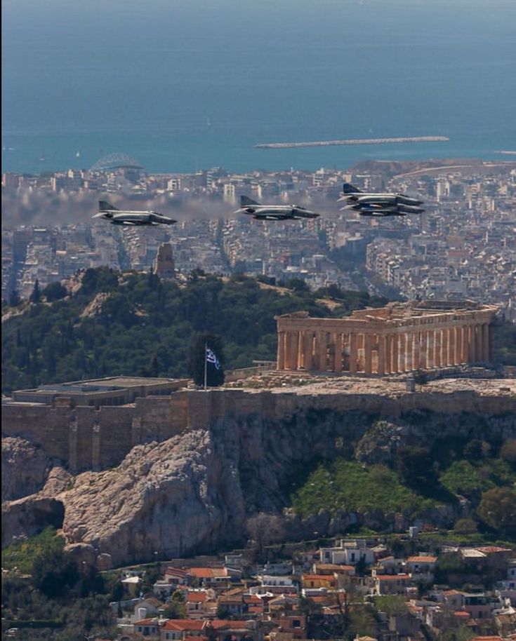 four jets fly over the acrobatic city of rome, with an island in the foreground