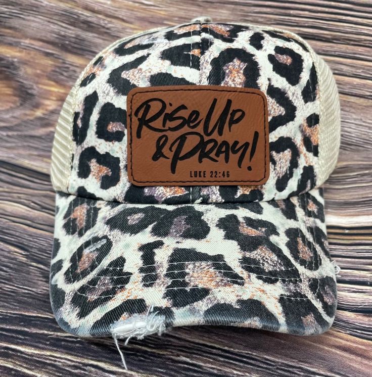 a leopard print trucker hat with the words res up and pray on it