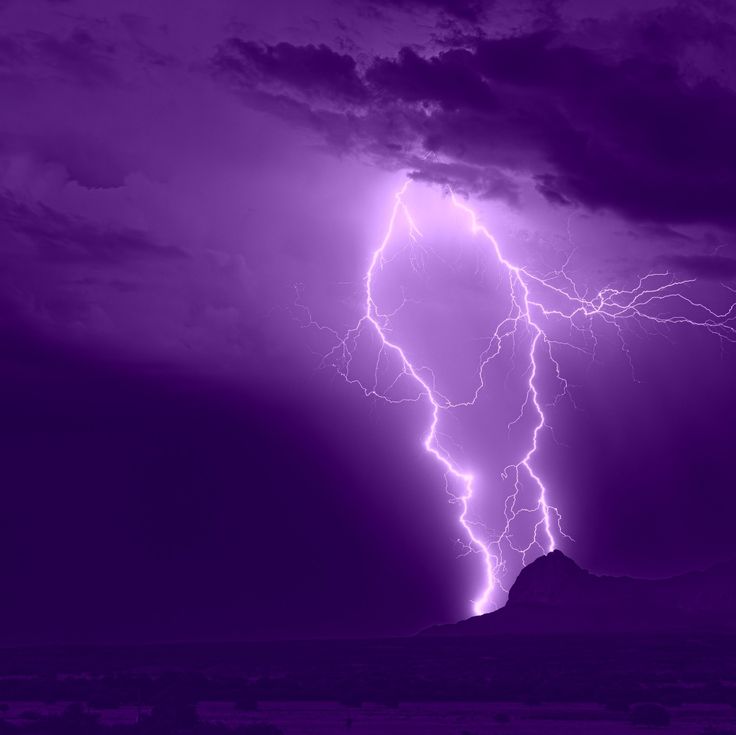 a purple sky with lightning striking through it