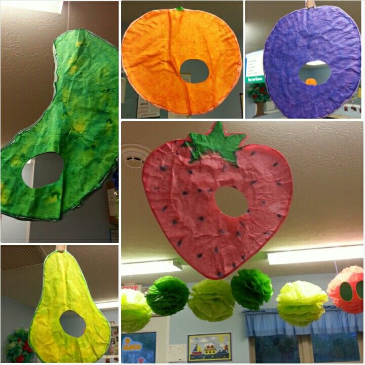 four pictures of different fruits and vegetables made out of paper plates hanging from the ceiling