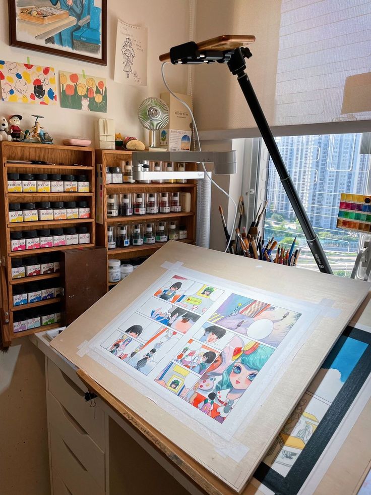 an artist's studio with lots of art supplies on the table and in front of it