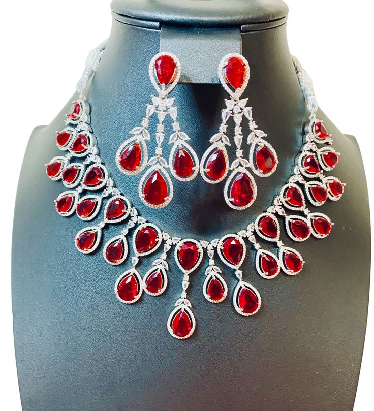 Enhance your jewelry collection with our CZ American Diamond and Red Stone Necklace set. This elegant set is perfect for any party or special occasion. The combination of CZ diamonds and red stones adds a touch of sophistication and glamour. Up your style game and stand out from the crowd with this stunning necklace set. Jewellery Care- Keep the jewellery dry, avoid contact with perfumes and water. Red Stone Necklace, Stone Necklace Set, Red Stones, Bridal Choker, Gem Necklace, Elegant Sets, American Diamond, Stunning Necklace, Cz Diamond