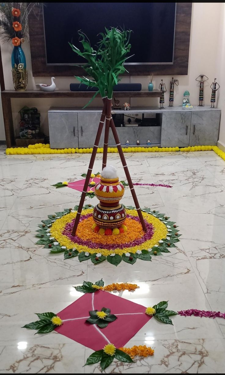 an arrangement of flowers and decorations on the floor in front of a flat screen tv